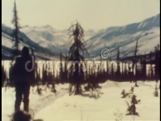 人拖着雪橇在雪地中的后视视频的预览图