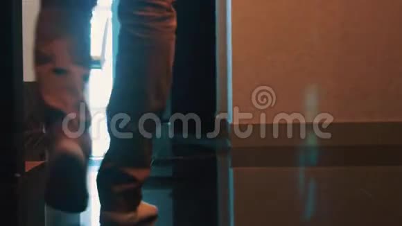 穿牛仔裤和袜子的男人在公寓的浴室里散步腿散步视频的预览图