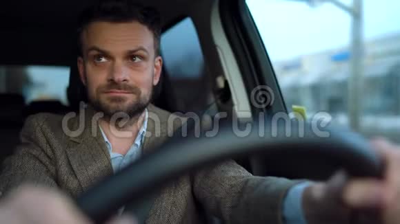 在晴朗的天气里一个满脸胡须的人开着一辆汽车在街上行驶视频的预览图