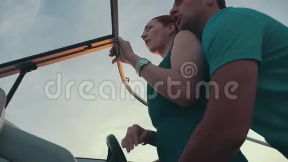 红发女孩穿着绿松石服装与男人一起驾驶摩托艇浪漫情侣视频的预览图