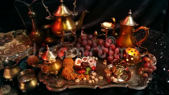 有东方珠宝店的女人喝茶吃传统的摩洛哥糖果萨弗龙马萨拉奶茶杯视频的预览图