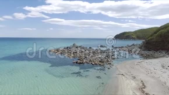 海岸湾的空中拍摄岩石和悬崖空中无人机拍摄的海浪冲刷在海滩上的岩石视频的预览图