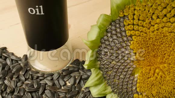 葵花籽向日葵花放在木桌上向日葵油倒在玻璃碗里倾斜视频的预览图