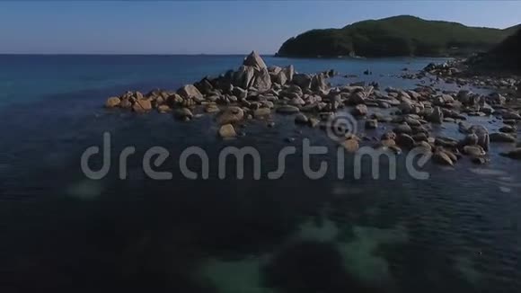 海岸湾的空中拍摄岩石和悬崖空中无人机拍摄的海浪冲刷在海滩上的岩石视频的预览图