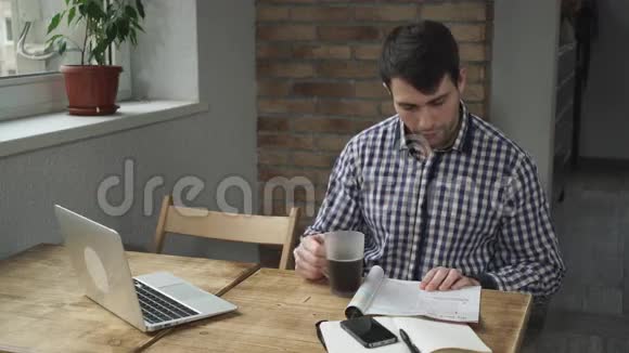 在咖啡馆里那个男人坐在桌子旁看杂志喝咖啡视频的预览图