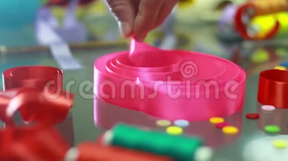 假日装饰品手从桌子上拿起粉红色的丝带装饰元素视频的预览图
