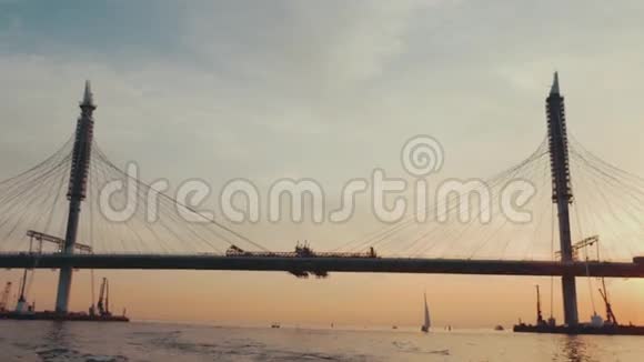 夏天晚上在城市里有一座巨大的桥美丽的日落河流自然视频的预览图