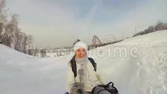 快乐的女孩骑着雪管在雪道上微笑慢动作冬天的雪景户外运动视频的预览图
