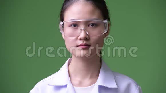 年轻漂亮的亚洲女医生戴着防护眼镜微笑视频的预览图