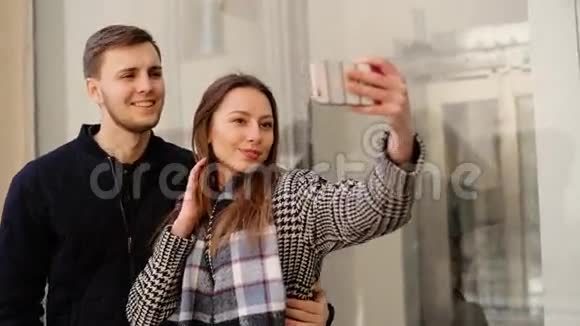 美丽迷人的微笑女人和她英俊的男朋友在电话里自拍视频的预览图