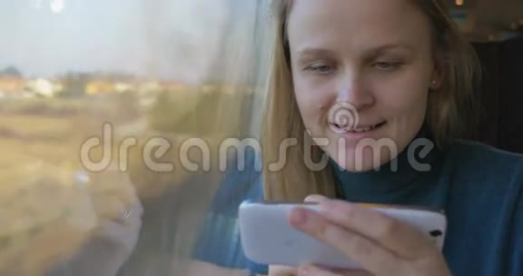 坐火车的女人用手机看着外面视频的预览图