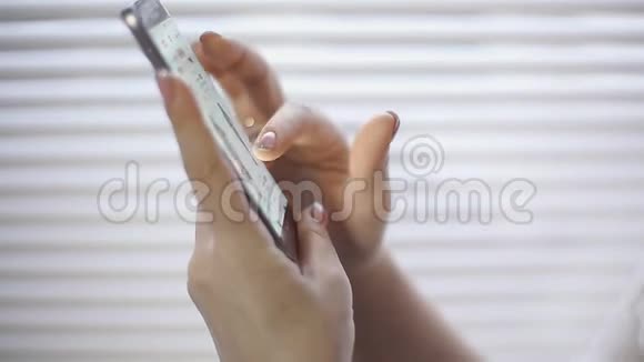 网上购物一名年轻女子在智能手机屏幕上浏览网上商店的商品视频的预览图
