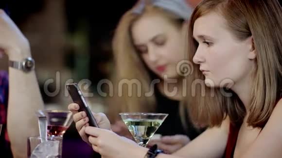 一群年轻人正在酒吧里看手机视频的预览图