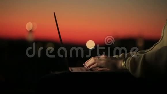 日落时分在笔记本电脑的键盘上用红色的美甲打字合上女人的手在Facebook上聊天的年轻女子视频的预览图