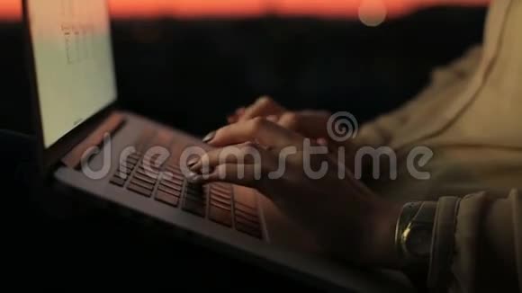 日落时分在笔记本电脑键盘上合上女人的手工作过程中的年轻女商人视频的预览图
