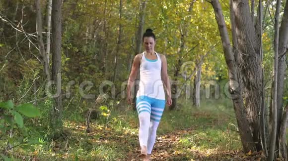 在户外树林里做瑜伽的年轻女人健康的生活方式视频的预览图