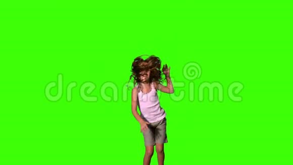 快乐的女孩在绿色的屏幕上跳跃视频的预览图