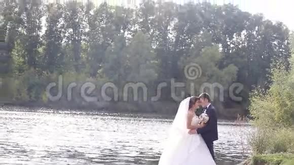 可爱的新婚夫妇站在附近接吻视频的预览图