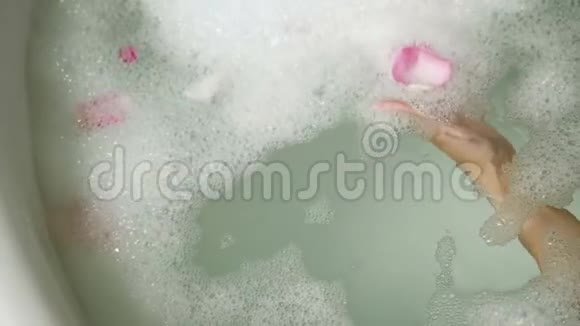 脚女孩躺在泡沫的圆形浴缸里视频的预览图