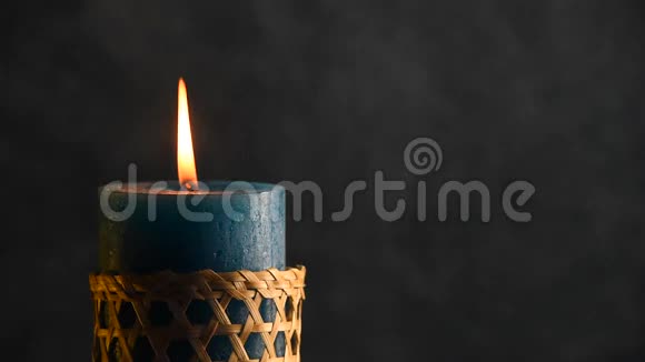 蓝色的蜡烛在灰色的背景下颤抖着火焰吹了出来视频的预览图