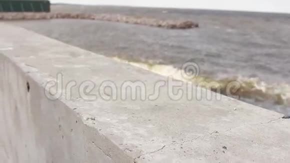 穿夹克的人把手放在靠近大海的码头上视频的预览图