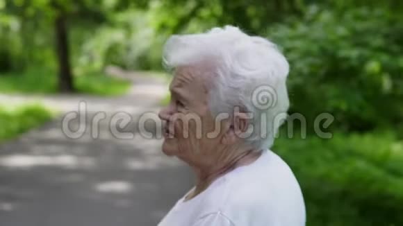 奶奶拿着棍子在公园里为北欧人散步视频的预览图