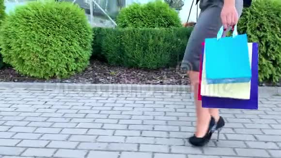 购物在黑色星期五假期一个女人拿着彩色的袋子在她的浅滩购物中心附近视频的预览图