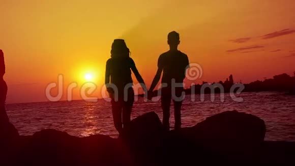 日落时分在海滩上散步的情侣视频的预览图
