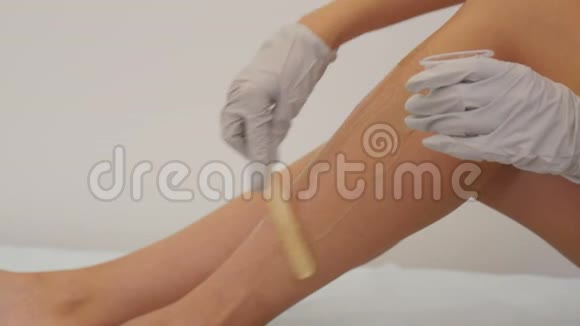 女性使用激光脱毛仪在医疗橱柜进行脱毛腿部的光扩张视频的预览图