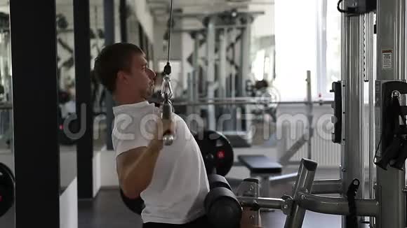 健身者在健身房用举重机做手臂视频的预览图