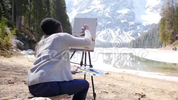 白云石一位年轻女子在画架上的画布上画画视频的预览图