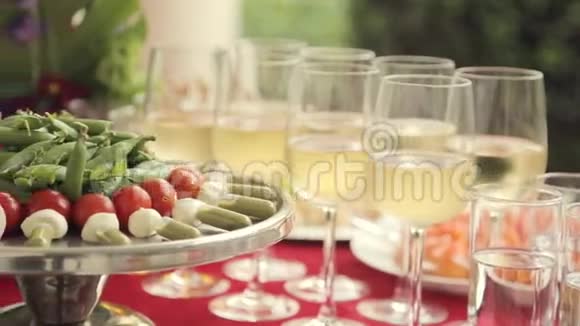 在宴会上托盘上的蔬菜和酒精倒入玻璃杯中视频的预览图