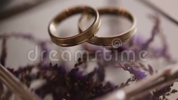 把紫色花朵上的金色结婚戒指收起来视频的预览图