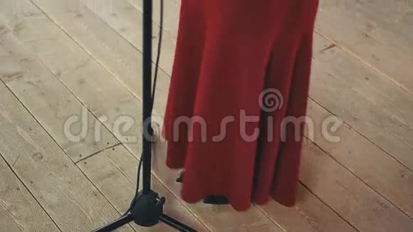 漂亮的歌手穿着红色的衣服在麦克风上有明亮的化妆表演舞蹈视频的预览图