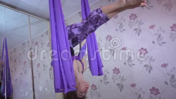 漂亮体贴的年轻女性用吊床做空中瑜伽姿势视频的预览图
