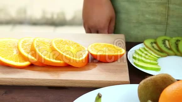 素食一个女人把一块橘子放在盘子上盘子在切割板上视频的预览图