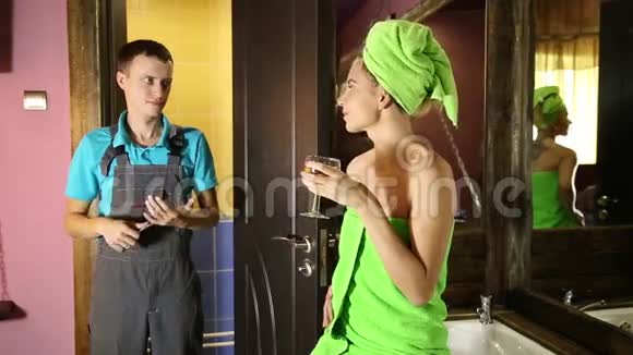在家里和年轻女孩调情的水管工男人与年轻的女性客户之前调情穿着浴巾的女孩视频的预览图