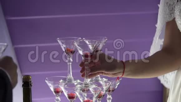 人们用香槟把酒倒进金字塔形的玻璃杯里视频的预览图