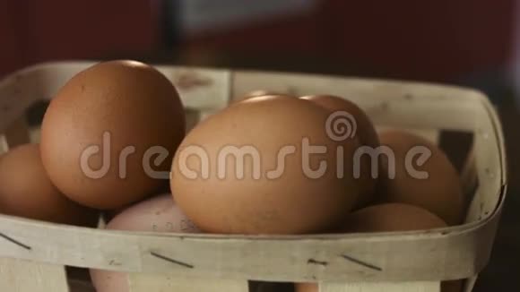 一个正在旋转的木板上躺着一篮子棕色鸡蛋的特写镜头视频的预览图