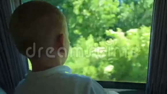 小男孩从敞开的公共汽车窗户往外看视频的预览图