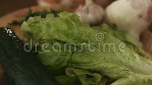 蔬菜在厨房的木盘上旋转的宏观镜头包括洋葱大蒜莴苣笋视频的预览图