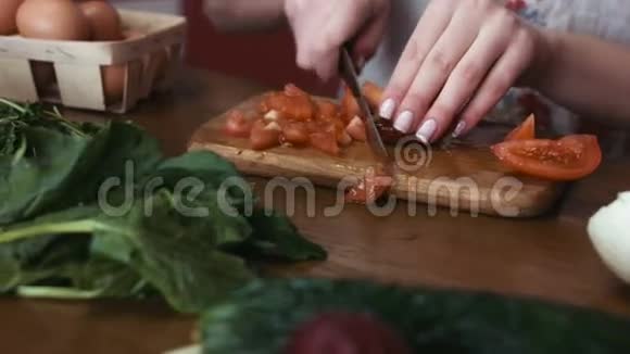 一只有法国指甲的雌性手正在切番茄片用来做沙拉绿色植物和视频的预览图