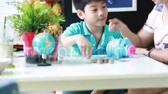 亚洲妈妈帮儿子存钱储蓄罐视频的预览图