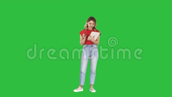 美丽的现代女性使用数字平板电脑上的绿色屏幕色度键视频的预览图