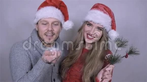 圣诞快乐的一对夫妇在白色的背景下吹雪视频的预览图