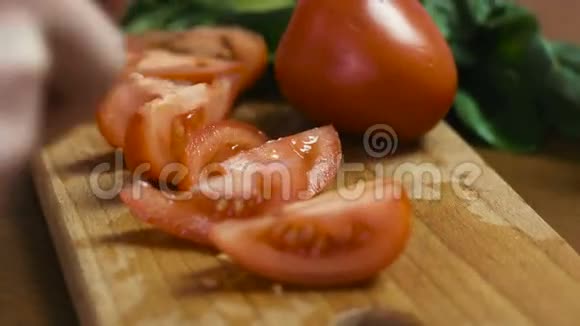 年轻女性的手在木板上把番茄切成大片的图片视频的预览图