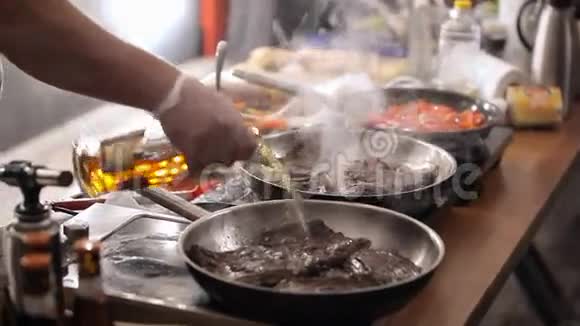 煮锅炸肉那个人在燃烧的煎锅上炸肉在煎锅上点火关门视频的预览图