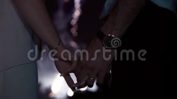 幸福的爱情夫妻牵着手一边放烟火视频的预览图