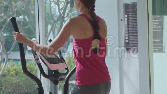 体育运动的年轻女子在公寓健身房的台步机上锻炼视频的预览图