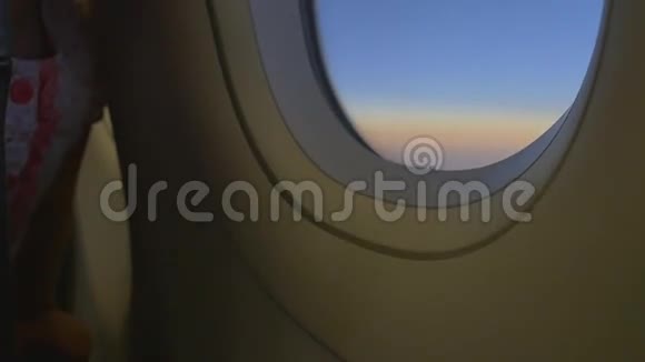 快乐的亚洲小女孩望着窗外的飞机视频的预览图